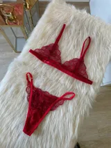 Conjunto de lencería compuesto por un bralette triangular de encaje con breteles regulables y una tanga de encaje regulable con corte media less.