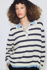 Jersey de punto con diseño a rayas horizontales en tonos crema, azul marino y marrón. Presenta cuello tipo polo en color celeste, cierre frontal con botones y puños y ruedo en tono celeste a juego.