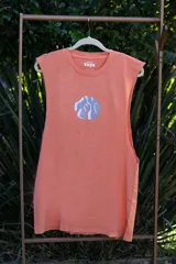 Musculosa color salmón con cuello redondo y estampado abstracto en el centro del pecho.