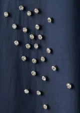 Camisa azul marino de lyocell y poliéster, con cuello camisero, manga larga, cierre frontal oculto con tapeta y detalles de apliques de strass y cristal en la parte delantera y las mangas.