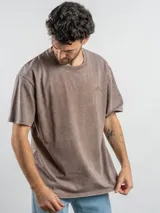 Remera oversize de algodón color negro con efecto lavado. Presenta un estampado gráfico en la espalda con la frase 'Freeze the moment' y un diseño de cámara fotográfica en tonos rojizos.