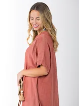 Vestido italiano largo color ladrillo, de lino 100%, con cuello tipo buche, mangas cortas y apliques de broderie en los hombros. Tiene tajos laterales.