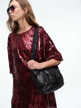 Vestido corto de corte recto y holgado, confeccionado en tejido cubierto de lentejuelas doradas. Presenta cuello redondo, mangas cortas amplias y una caída fluida.