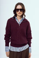 Sweater de tejido de punto color bordó, con cuello alto, cierre frontal parcial y mangas largas.