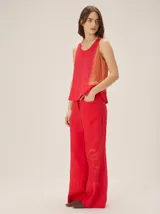 Pantalon de lino color rojo, de corte recto y holgado, con bolsillos laterales y sutil estampado en la pierna.