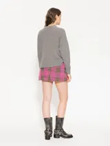 Minifalda de tweed con motivo pied de poule en fucsia y negro, de tiro alto con bolsillos frontales con solapa y botón dorado decorativo.