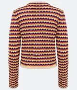 Chaqueta de punto de manga larga, cuello redondo y cierre frontal con botones de madera. Presenta un patrón de rayas horizontales en zigzag con colores crema, mostaza, fucsia y morado.