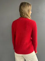 Sweater de punto color rojo con diseño de ochos en el frente y tejido morley en mangas y espalda. Presenta cuello redondo a la base, manga larga y calce ajustado.