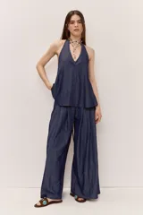 Pantalón de pierna ancha color azul, con pliegues frontales y caída suave.