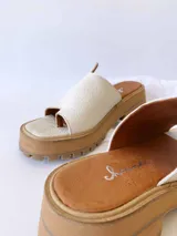 Sandalias de cuero crudo con tira ancha sobre los dedos y suela track color caramelo.