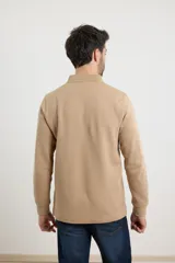 Sweater de tejido elastizado de algodón y poliéster color tostado, con cuello estilo tunecino, cierre frontal parcial con botones y ribetes en contraste.