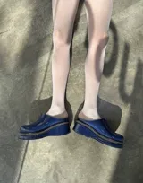 Suecos de charol azul con plataforma y costuras blancas.