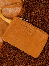 Cartera tipo hobo de gran tamaño, con forma envolvente y asa integrada. Presenta un diseño bicolor y de texturas mixtas: una sección es de cuero negro texturizado y la otra de material afelpado negro (tipo borrego o sherpa).