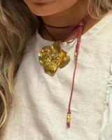 Collar con dije grande de bronce con forma orgánica y textura rugosa, suspendido de un cordón negro. Incluye cordones intercambiables.