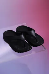 Sandalias de baño color negro, con diseño tipo ojota de suela gruesa y plantilla texturizada.