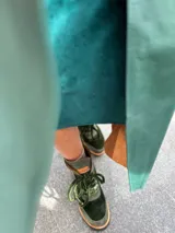 Borcegos de gamuza y terciopelo color azul marino, con detalles en color cobre y suela de goma negra. Cierre con cordones.