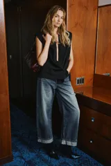 Chaleco de cuello solapa y escote en pico cruzado. Presenta diseño sin mangas con hombreras marcadas, bolsillos de vivo en el delantero y cierre frontal cruzado con botones. Incluye un cinturón de lazada en el mismo tejido para ajustar a la cintura y cuenta con forro interior.