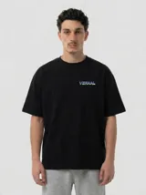 Remera de algodón premium color negro, con corte relajado. Presenta un diseño gráfico estampado en la espalda que combina tonos violeta y verde ácido, con una ilustración conceptual de estilo urbano.