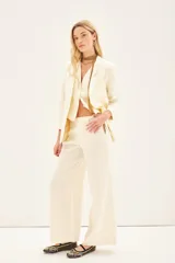 Pantalon de corte sastrero con diseño de pierna ancha y tiro medio. Presenta bolsillos laterales y cierre frontal oculto.