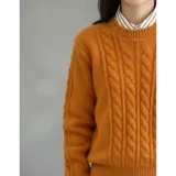 Buzo de punto blanco de manga larga con diseño trenzado y cuello redondo.