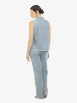 Musculosa de denim celeste, con cuello polo, escote en V con botones, sin mangas, de fit amplio y terminación desflecada.