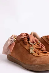 Zapatillas de gamuza color marrón con suela de goma color caramelo. Presentan cordones al tono y un detalle decorativo de pañuelo estampado atado en los laterales con esferas metálicas doradas.