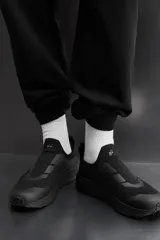 Zapatilla deportiva negra sin cordones para uso diario y carreras ligeras. Parte superior de tejido de punto transpirable, puntera y talón recubiertos de material Shield Protect Max, tirador trasero, plantilla OrthoLite® extraíble, entresuela con tecnología Spume Foam V3 y suela de goma. Zara Athleticz.