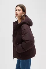 Campera puffer de color marrón oscuro, con diseño capitoneado, cierre frontal, capucha ajustable y bolsillos laterales con cierre.