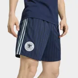 Short de fútbol Adidas de la colección Alemania Originals, color azul marino con diseño de rayas verticales sutiles. Presenta las tres tiras características de la marca en los laterales en color celeste y el escudo de la selección alemana en el muslo derecho.