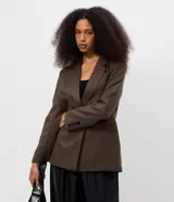 Blazer sastrero de corte alargado con estampado de cuadros pequeños en tonos marrones. Presenta cuello con solapa, cierre frontal con dos botones y mangas largas.