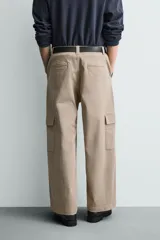 Pantalón cargo de corte relajado confeccionado en tejido de algodón con elasticidad. Presenta bolsillos laterales tipo cargo con solapa en las perneras, bolsillos frontales y bolsillos traseros de doble vivo. Cierre frontal con cremallera y botón.