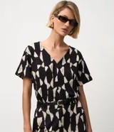 Blusa de manga corta color negro con estampado geométrico en tono beige, escote en V y corte amplio.