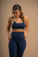 Conjunto deportivo azul marino compuesto por un top con breteles blancos y calzas largas de tiro alto con bolsillos laterales.