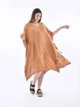Vestido de tela fluida color marrón medio, con escote en V y mangas cortas tipo kimono. El ruedo es asimétrico con aberturas laterales.