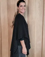 Ruana tejida en algodón con destellos de lurex, de corte amplio y diseño abierto, con textura en punto relieve.