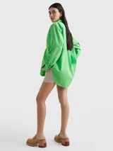 Camisa verde de popelín de algodón orgánico, corte oversize con hombros caídos, cuello inglés, bolsillo de parche en el pecho y logo bordado en la manga.