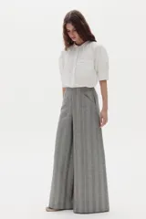 Pantalón gris de lino con diseño a cuadros, tiro medio-alto, pierna ancha y bolsillos laterales.
