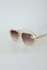 Lentes de sol con armazón de policarbonato negro y cristales tonalidad ámbar, con diseño de puente doble estilo aviador.
