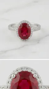 Anillo de plata 925 con piedra central de raíz de rubí en corte ovalado, rodeada por un halo de circonias y banda decorada con circonias adicionales.