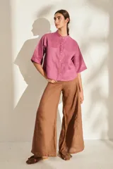Pantalón de lino blanco de corte wide leg, con diseño amplio y costuras pespunteadas a contratono.