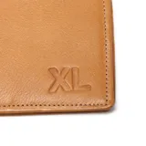 Billetera de cuero vacuno color suela, con diseño plegable y el logo de la marca grabado en relieve en la esquina inferior derecha.