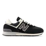 Championes urbanos New Balance modelo 574, color negro con detalles en blanco y gris. Confeccionados en cuero y malla, cuentan con el logo N característico en los laterales y entresuela con tecnología ENCAP para mayor amortiguación y soporte.