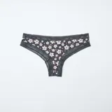 Pack de tres tangas de microfibra con detalles de encaje en la cintura y los bordes. El conjunto incluye una tanga negra con estampado floral, una tanga lisa en tono nude y una tanga marrón con estampado de flores pequeñas.