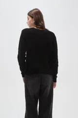 Sweater de punto color natural con diseño de ochos, cuello redondo y mangas largas de calce holgado.