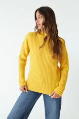 Sweater amarillo tejido con cuello alto y mangas largas. Diseño de punto acanalado. Corte regular.