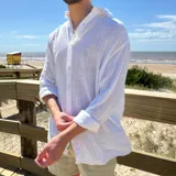 Camisa blanca de lino con corte oversize y mangas largas.