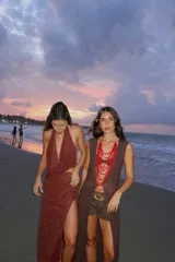 Falda larga tejida color marrón con brillo metálico, corte al cuerpo, abertura alta en la pierna y recortes laterales con cordones ajustables.