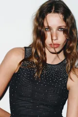 Top sin mangas, color azul marino, con cuello redondo y aplicación de brillos plateados que se dispersan desde el escote hacia el cuerpo.