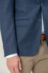 Saco de vestir con diseño de espiga en color marrón, confeccionado en mezcla de lana y seda. Presenta solapas clásicas, cierre frontal de dos botones y bolsillos laterales con solapa.