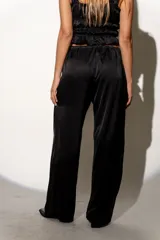 Pantalón de satén con estampado animal print, corte holgado y cintura ajustable con lazo.